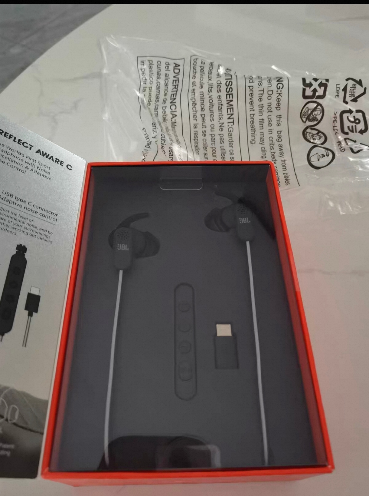 JBL REFLECT AWARE C 包装内的耳机和控制器